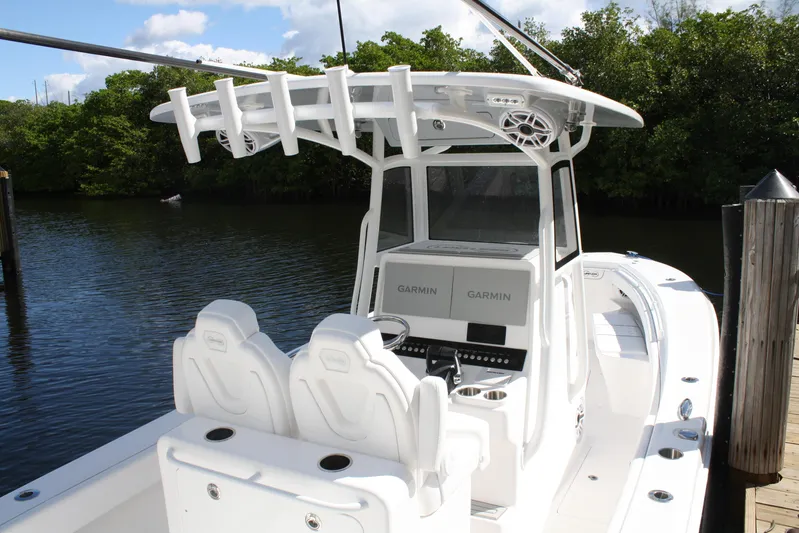  Yacht Photos Pics Limitless 270 boat, 2026 model, with dual Garmin displays, docked by lush greenery.