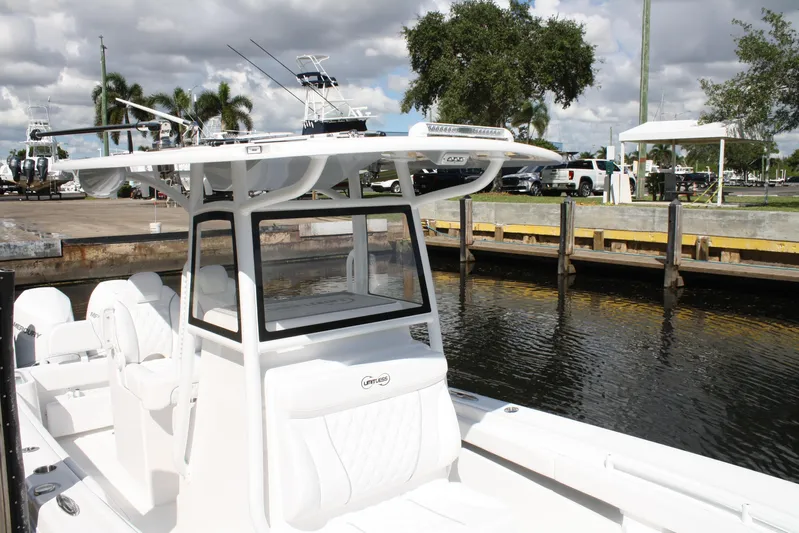  Yacht Photos Pics White Limitless 270 boat docked by the water, showcasing sleek design and modern features.