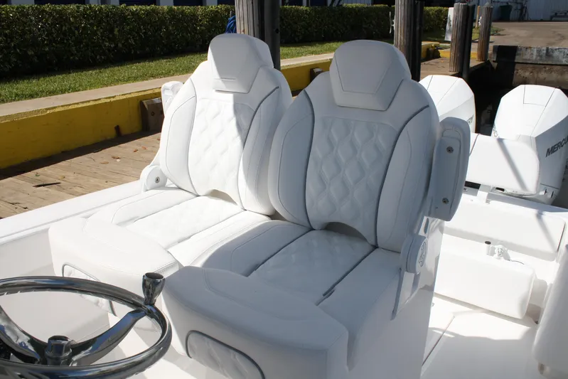  Yacht Photos Pics Luxurious white seating on Limitless 270 boat, 2026 model, with quilted design and steering wheel.