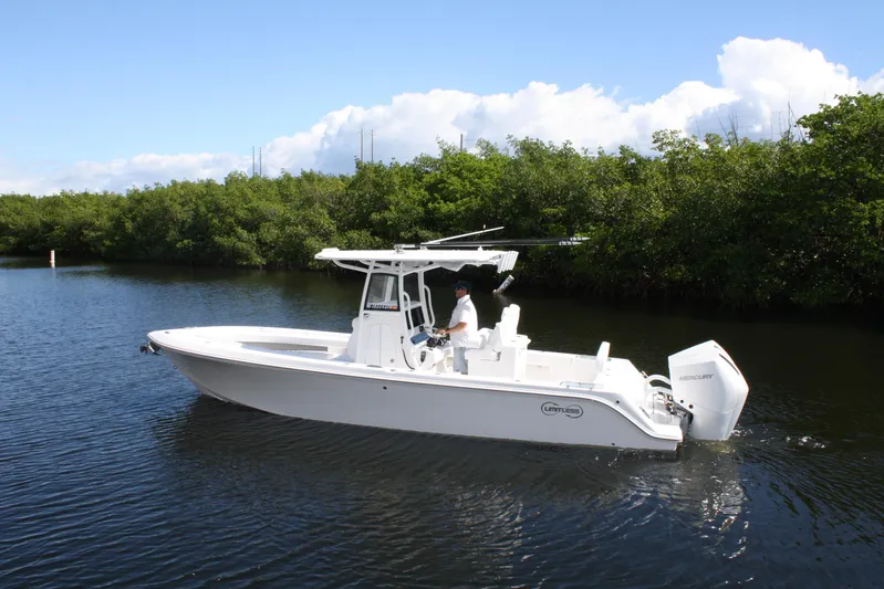  Yacht Photos Pics 2026 Limitless 270 boat cruising on a calm river with lush greenery.