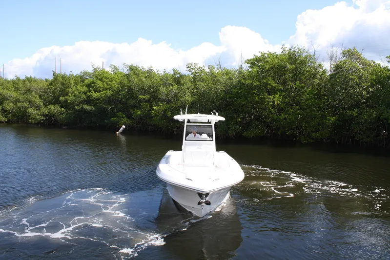  Yacht Photos Pics Limitless 270 boat cruising on a calm river, surrounded by lush greenery, 2026 model.