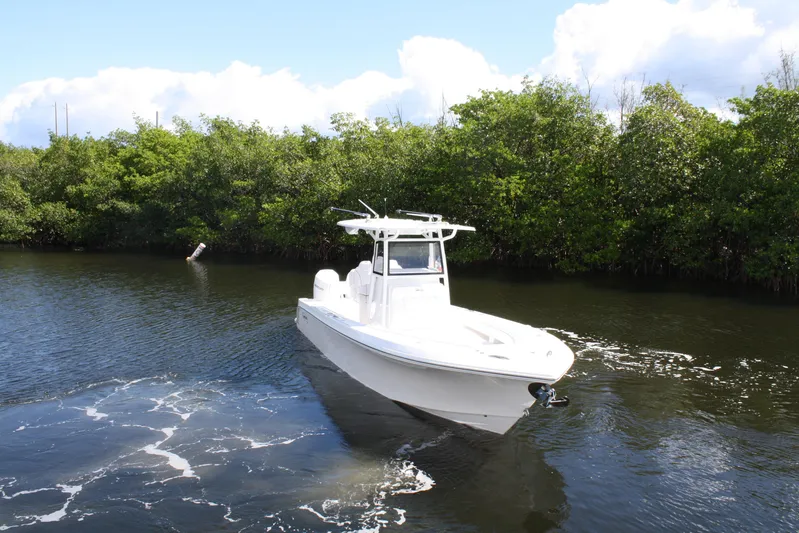  Yacht Photos Pics White Limitless 270 boat cruising on a calm river, surrounded by lush greenery, 2026 model.
