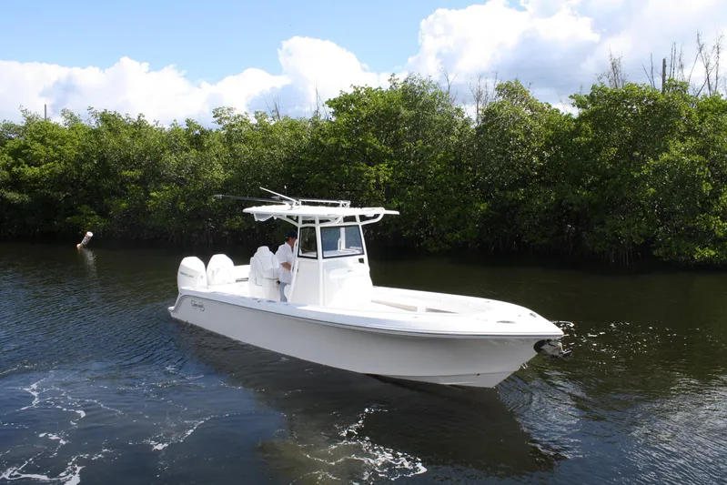  Yacht Photos Pics White Limitless 270 boat cruising on a calm river, surrounded by lush greenery, 2026 model.