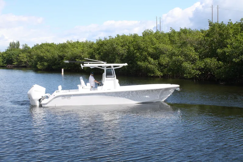  Yacht Photos Pics 2026 Limitless 270 boat cruising on a calm river with lush greenery.