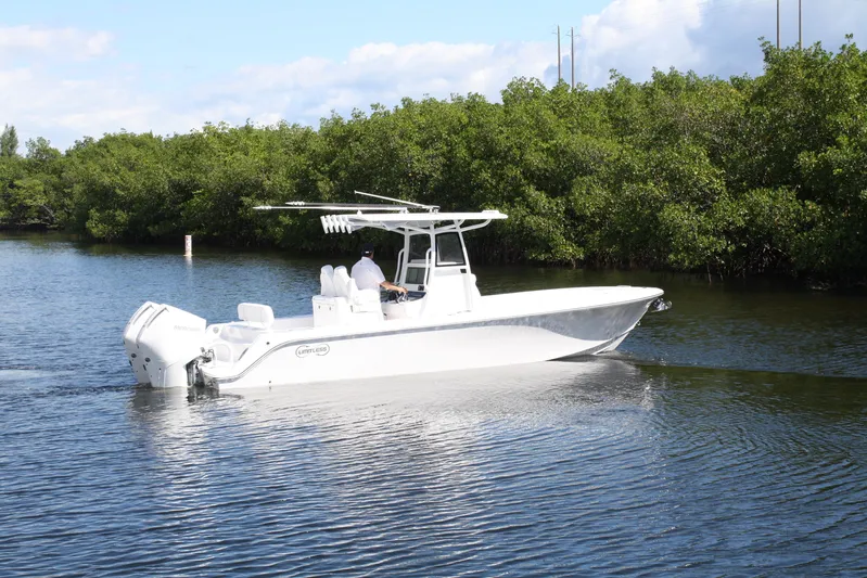  Yacht Photos Pics 2026 Limitless 270 boat cruising on a calm river with lush greenery.