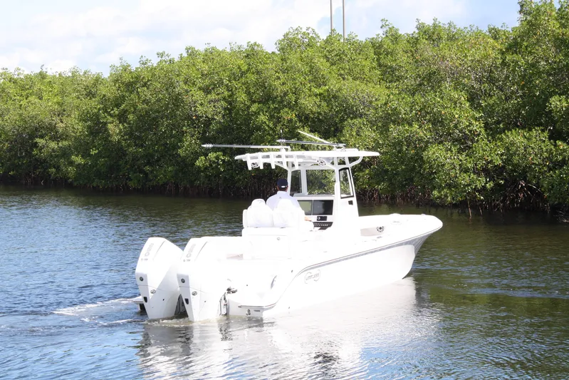  Yacht Photos Pics White Limitless 270 boat cruising on a calm river, surrounded by lush greenery, 2026 model.