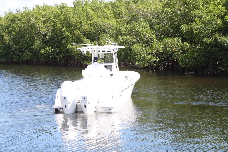  Yacht Photos Pics A 2026 Limitless 270 boat navigating a serene waterway surrounded by lush greenery.