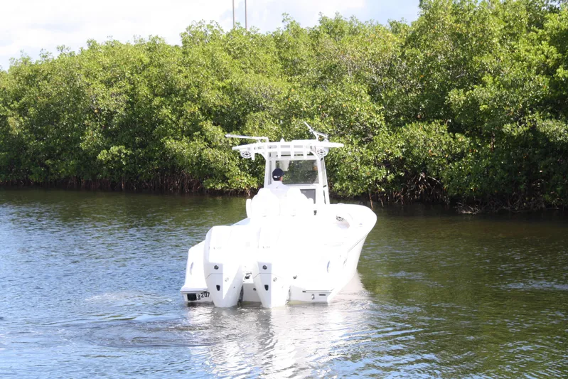  Yacht Photos Pics Limitless 270 boat cruising on a calm river, surrounded by lush greenery, 2026 model.