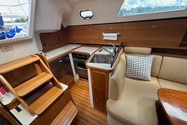  Yacht Photos Pics 2015 Catalina 315 yacht interior with wooden cabinetry, compact kitchen, and cozy seating area.