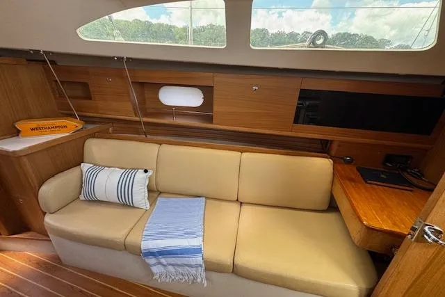  Yacht Photos Pics Interior of 2015 Catalina 315 sailboat with beige sofa, striped pillow, and wooden accents.