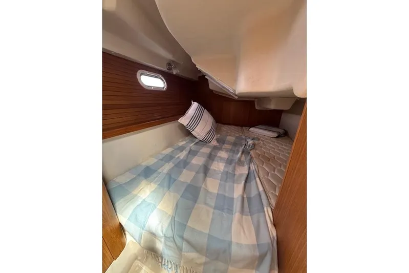  Yacht Photos Pics Cozy cabin interior of 2015 Catalina 315 sailboat with checkered bedding and pillows.