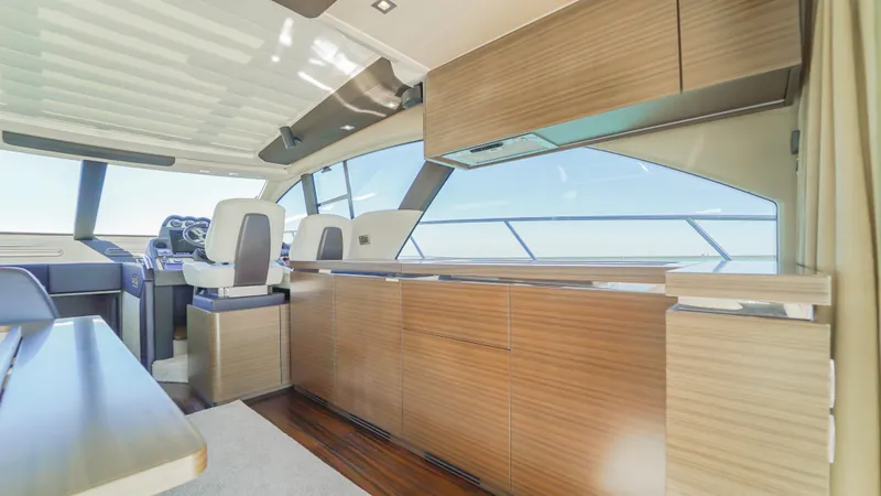 Brigadone Yacht Photos Pics Interior of 2016 Azimut 55S yacht, featuring modern wood cabinetry and panoramic windows.