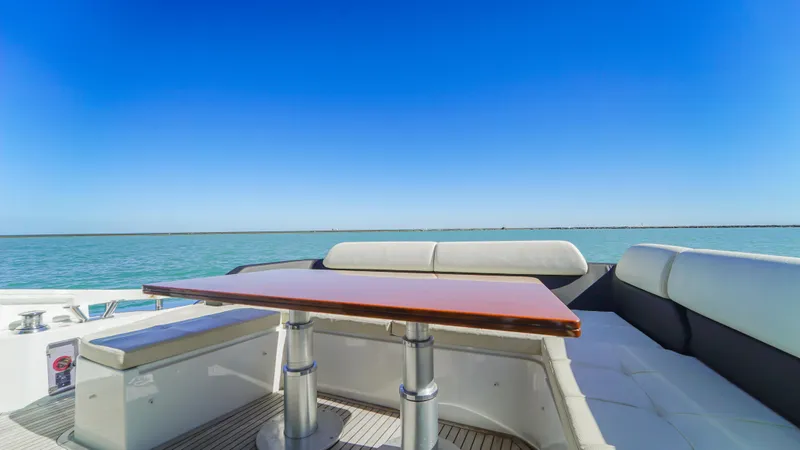 Brigadone Yacht Photos Pics 2016 Azimut 55S yacht deck with seating and table, overlooking calm blue waters.