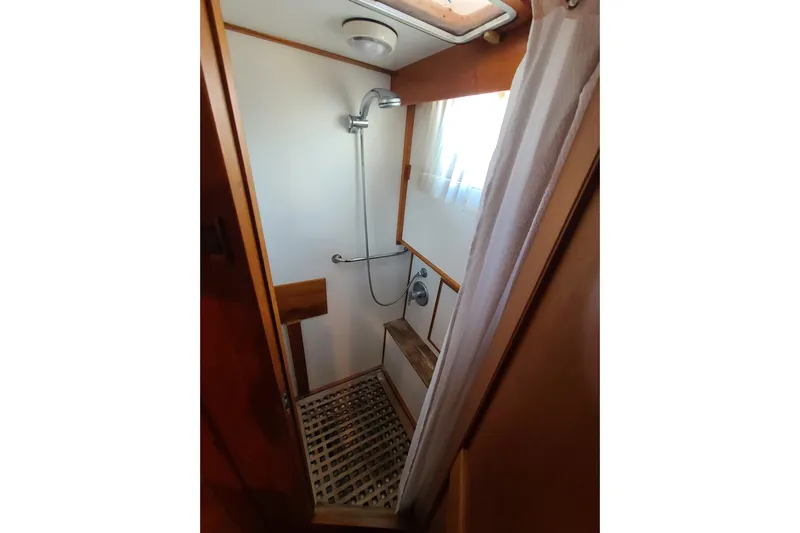 Breakaway Yacht Photos Pics Shower area in 2000 Grand Banks 46 Classic yacht with wooden accents and curtain.