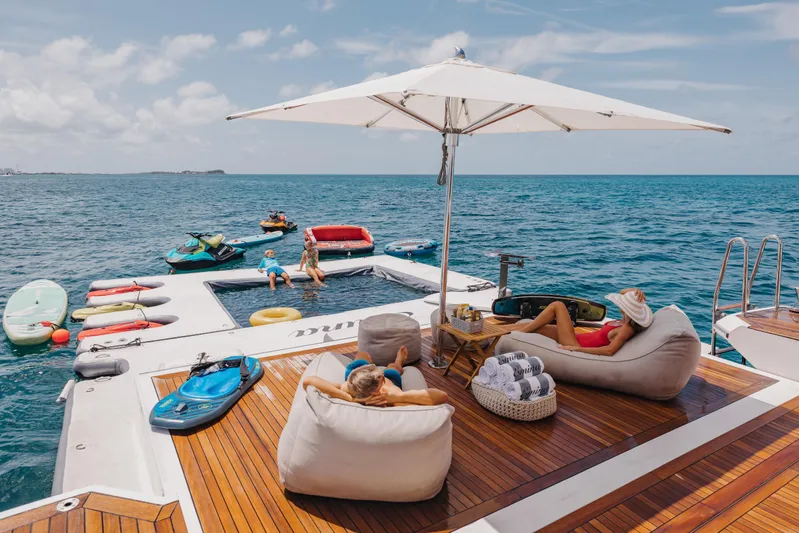 Emina Yacht Photos Pics Luxurious Benetti Veloce 140 yacht deck with sunbathers, water toys, and ocean view.