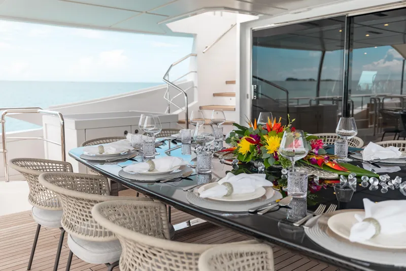 Emina Yacht Photos Pics Luxurious dining setup on 2014 Benetti Veloce 140 yacht, featuring elegant tableware and floral centerpiece.