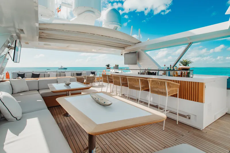 Emina Yacht Photos Pics Luxurious 2014 Benetti Veloce 140 yacht deck with bar, seating, and ocean view.