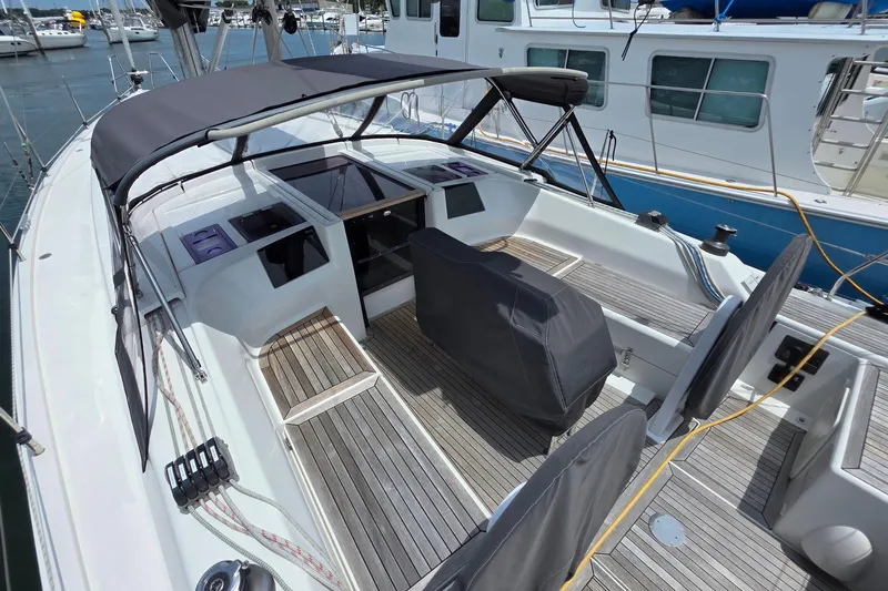 Quantum Yacht Photos Pics 2014 Hanse 385 sailboat cockpit with covered seating and wooden deck, docked at marina.
