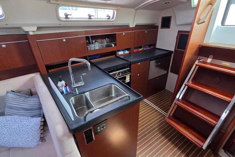 Quantum Yacht Photos Pics Interior of 2014 Hanse 385 yacht featuring modern kitchen and wooden cabinetry.