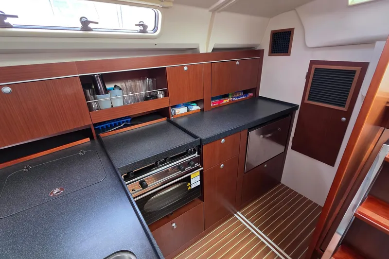 Quantum Yacht Photos Pics Modern galley kitchen in 2014 Hanse 385 yacht with wood cabinetry and sleek countertops.
