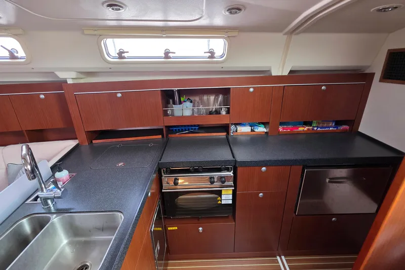 Quantum Yacht Photos Pics Modern kitchen interior of 2014 Hanse 385 yacht with wooden cabinets and stainless steel sink.