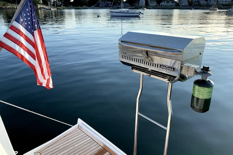 Quantum Yacht Photos Pics Hanse 385 sailboat with American flag and Magma grill on calm water, 2014 model.
