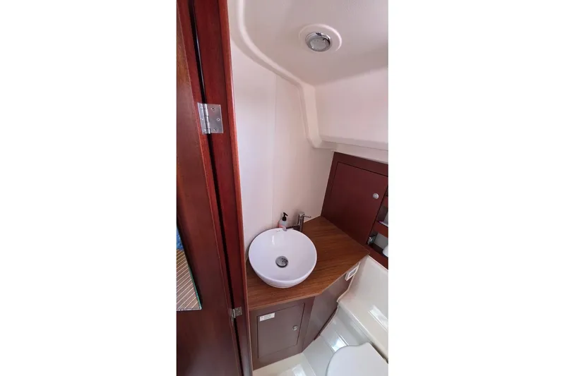Quantum Yacht Photos Pics Bathroom interior of 2014 Hanse 385 yacht with modern sink and wooden cabinetry.