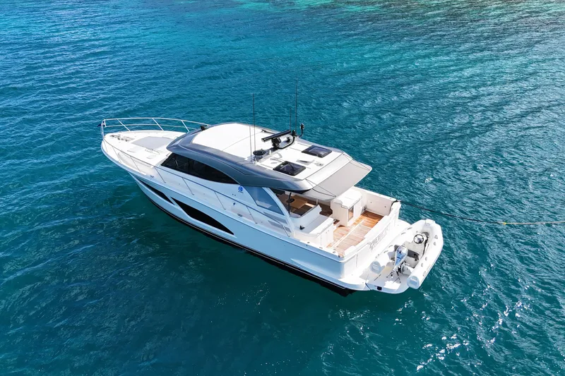  Yacht Photos Pics 2023 Riviera 465 SUV yacht cruising on clear blue ocean waters.