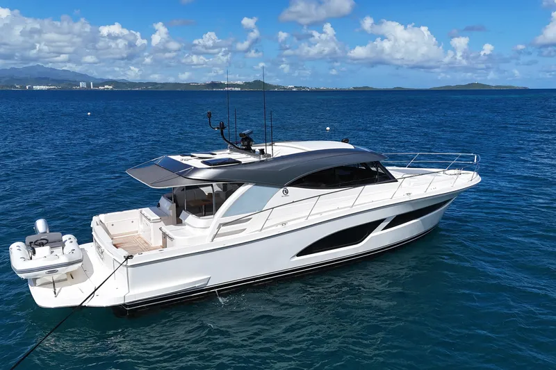  Yacht Photos Pics 2023 Riviera 465 SUV yacht cruising on clear blue ocean waters.