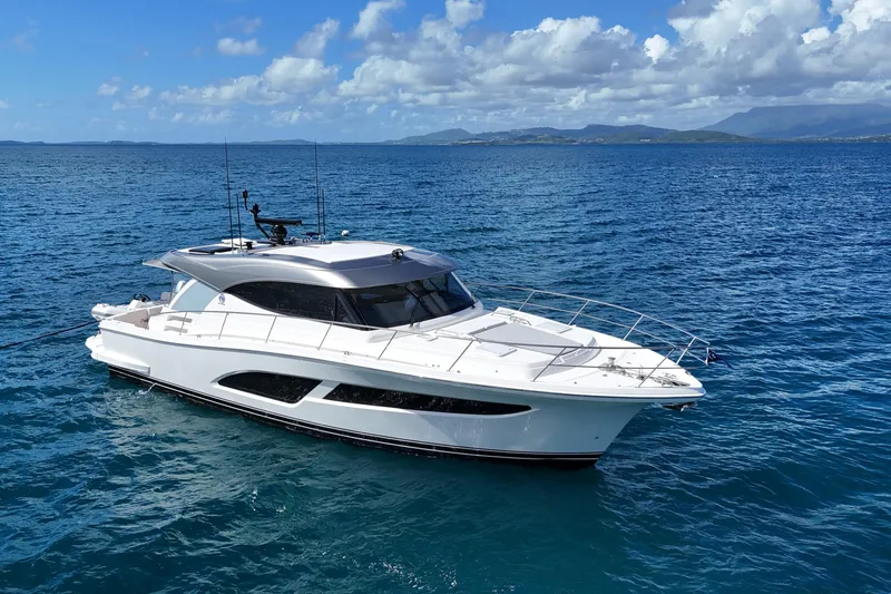  Yacht Photos Pics 2023 Riviera 465 SUV yacht cruising on open blue sea under clear skies.