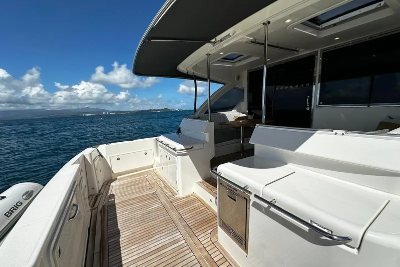 Yacht Photos Pics 2023 Riviera 465 SUV yacht deck with seating, ocean view, and clear blue sky.