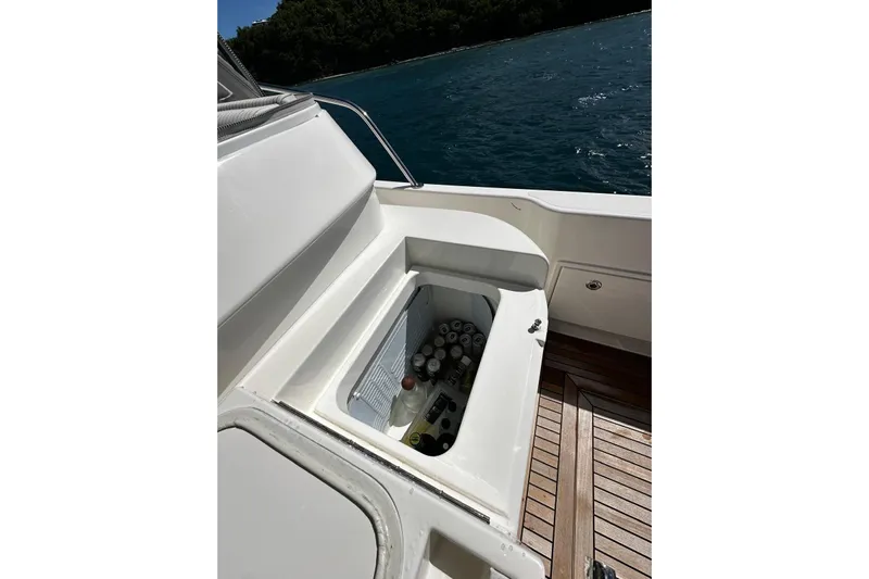  Yacht Photos Pics Riviera 465 SUV 2023 yacht with built-in cooler, stocked with beverages, on a sunny day.