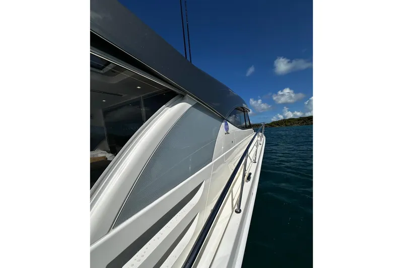  Yacht Photos Pics 2023 Riviera 465 SUV yacht on calm blue waters under a clear sky.