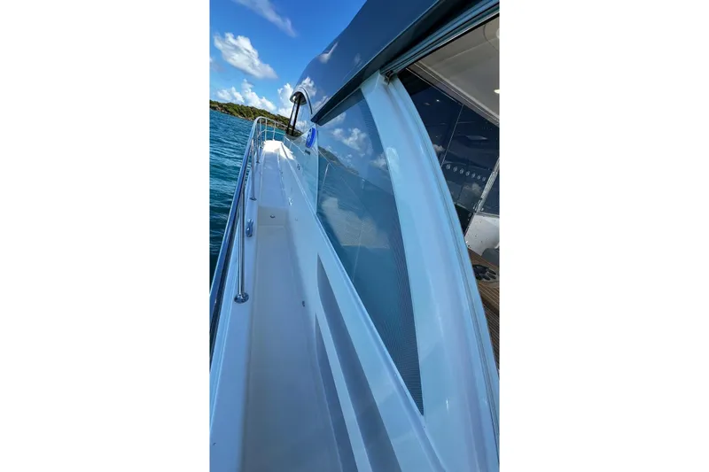  Yacht Photos Pics Side view of 2023 Riviera 465 SUV yacht, showcasing sleek design and ocean backdrop.