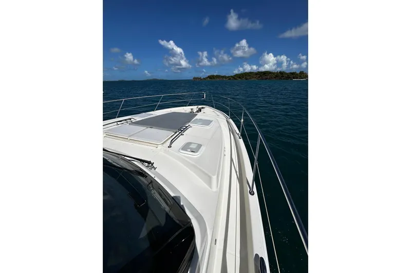  Yacht Photos Pics 2023 Riviera 465 SUV yacht cruising on open water under clear blue skies.