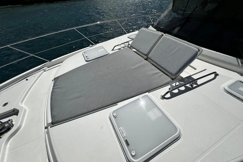  Yacht Photos Pics 2023 Riviera 465 SUV yacht with sunbathing deck, sleek design, and ocean backdrop.
