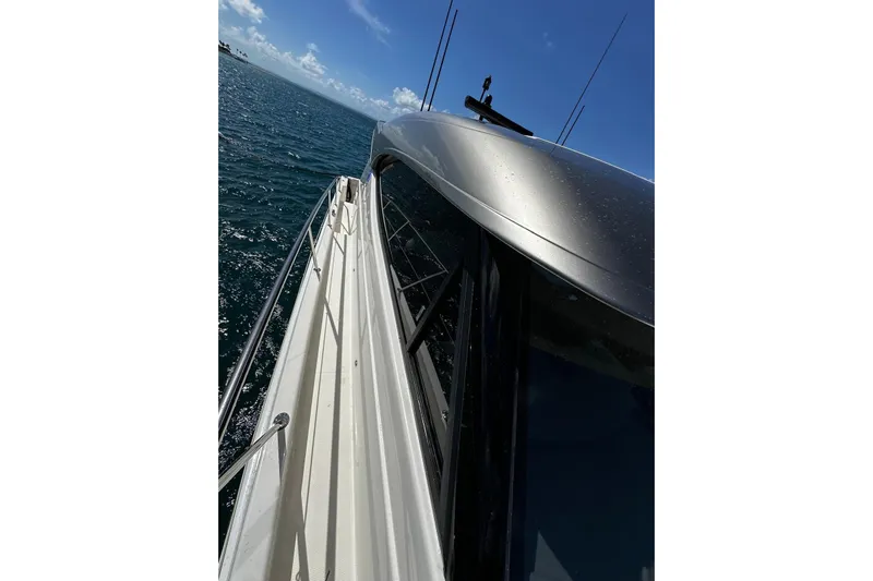  Yacht Photos Pics 2023 Riviera 465 SUV yacht cruising on open water under clear blue sky.