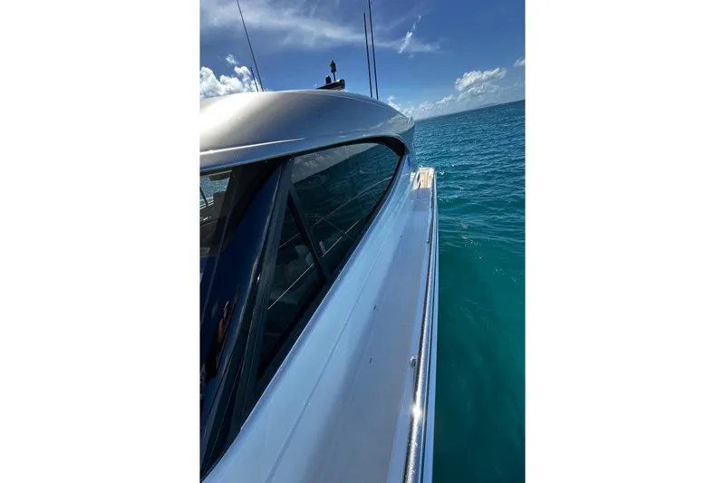  Yacht Photos Pics 2023 Riviera 465 SUV yacht cruising on clear blue ocean waters.