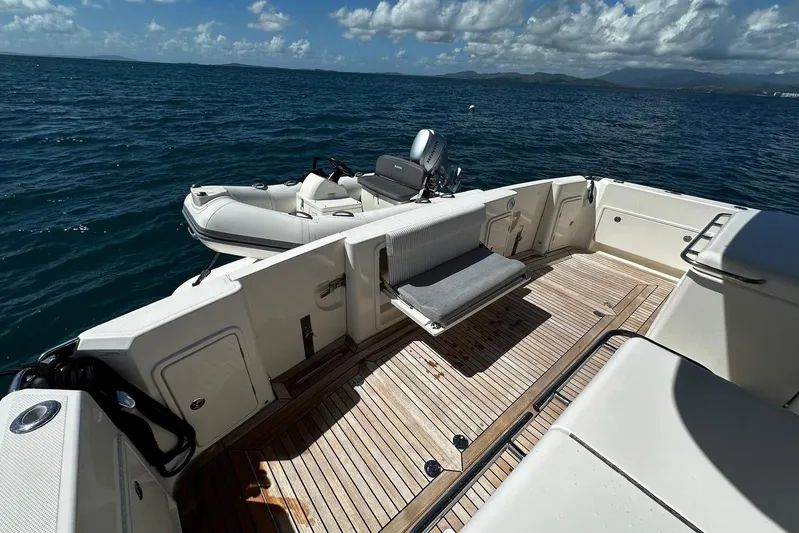  Yacht Photos Pics 2023 Riviera 465 SUV yacht deck with tender, ocean view, and clear skies.