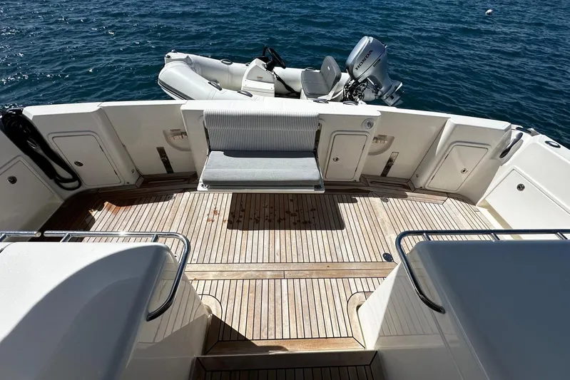  Yacht Photos Pics 2023 Riviera 465 SUV yacht deck with wooden flooring and attached dinghy.