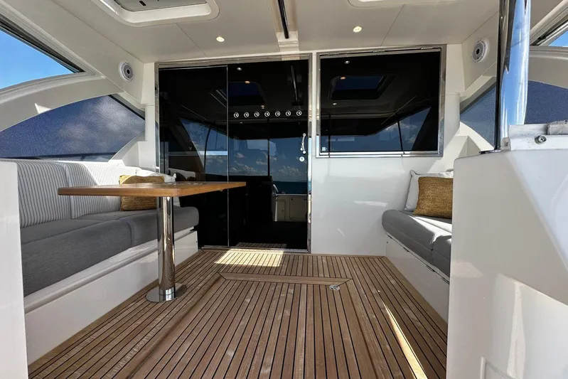  Yacht Photos Pics 2023 Riviera 465 SUV interior with wooden flooring and comfortable seating.