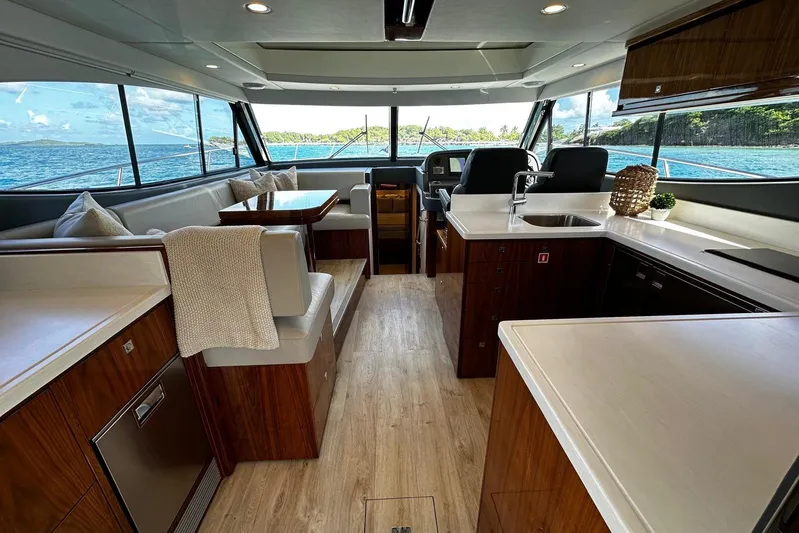  Yacht Photos Pics Luxurious interior of 2023 Riviera 465 SUV yacht with modern kitchen and seating area.