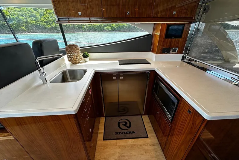  Yacht Photos Pics Luxurious kitchen interior of 2023 Riviera 465 SUV yacht with modern amenities and scenic view.