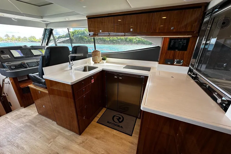  Yacht Photos Pics Luxurious interior of 2023 Riviera 465 SUV yacht with modern kitchen and navigation area.