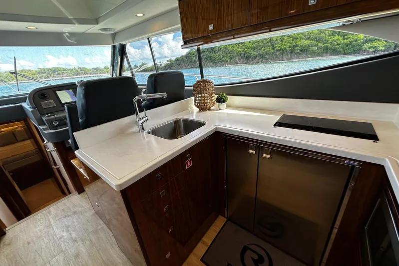  Yacht Photos Pics Luxurious interior of 2023 Riviera 465 SUV yacht with modern kitchen and scenic view.