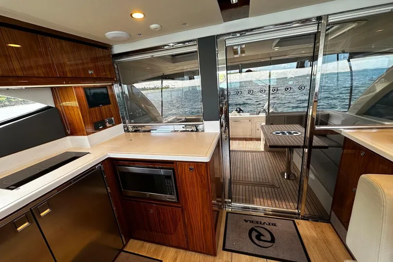  Yacht Photos Pics Luxurious interior of 2023 Riviera 465 SUV yacht with modern kitchen and ocean view.
