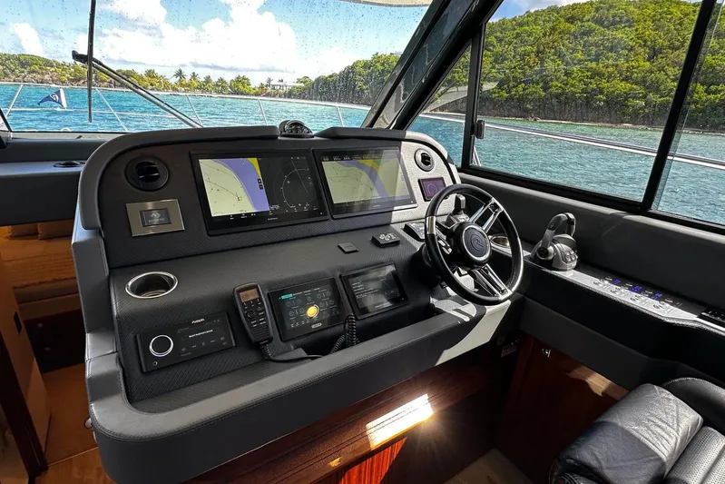  Yacht Photos Pics 2023 Riviera 465 SUV helm with advanced navigation systems and scenic ocean view.