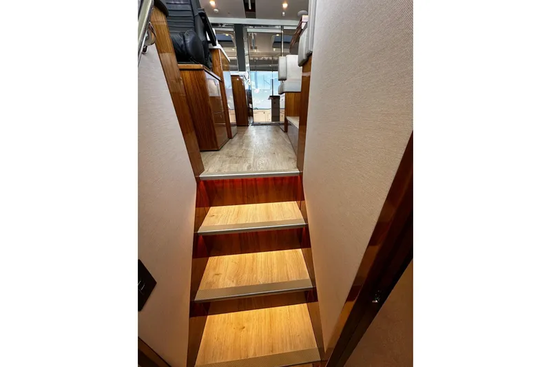  Yacht Photos Pics Interior stairs of 2023 Riviera 465 SUV yacht, featuring elegant wood finish and modern design.
