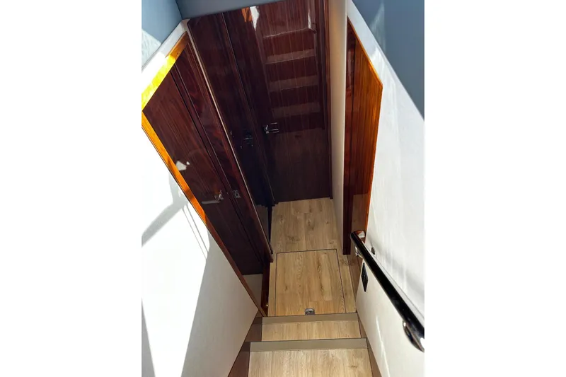  Yacht Photos Pics Interior staircase of 2023 Riviera 465 SUV yacht with wooden finishes.