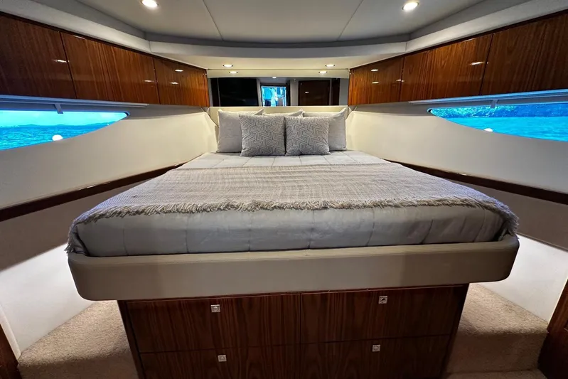  Yacht Photos Pics Luxurious bedroom interior of 2023 Riviera 465 SUV yacht with elegant wood finishes.